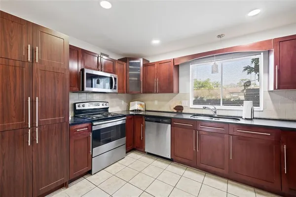 a kitchen with stainless steel appliances granite countertop a stove top oven a sink and dishwasher