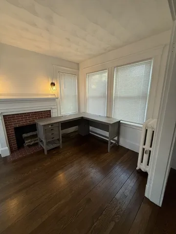 a room with wooden floor and a fireplace