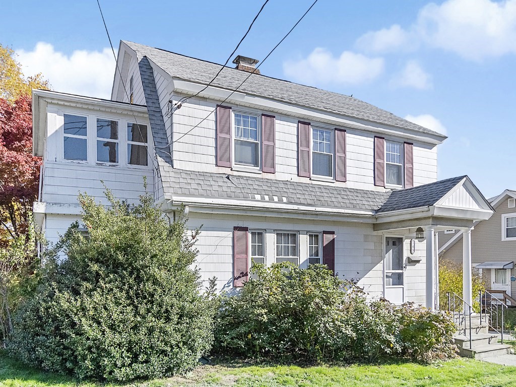 front view of a brick house with a yard