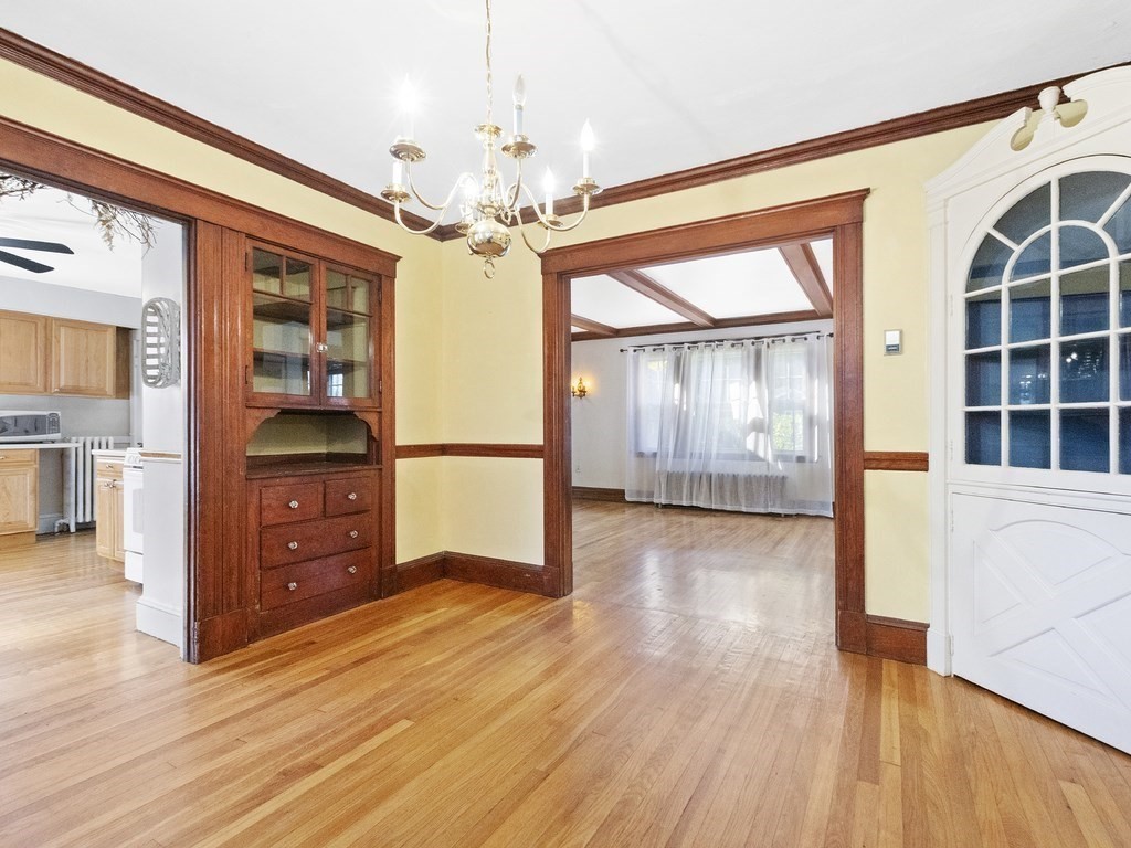 149 Trapelo Road Waltham, MA 02452 - Photo 14 of 36 a view of a hallway with wooden floor and chandelier