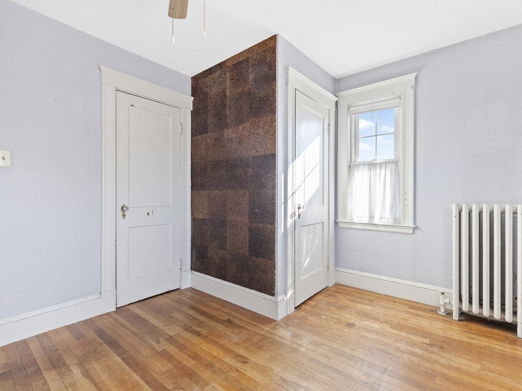 149 Trapelo Road Waltham, MA 02452 - Photo 20 of 36 a view of an empty room with wooden floor and a window