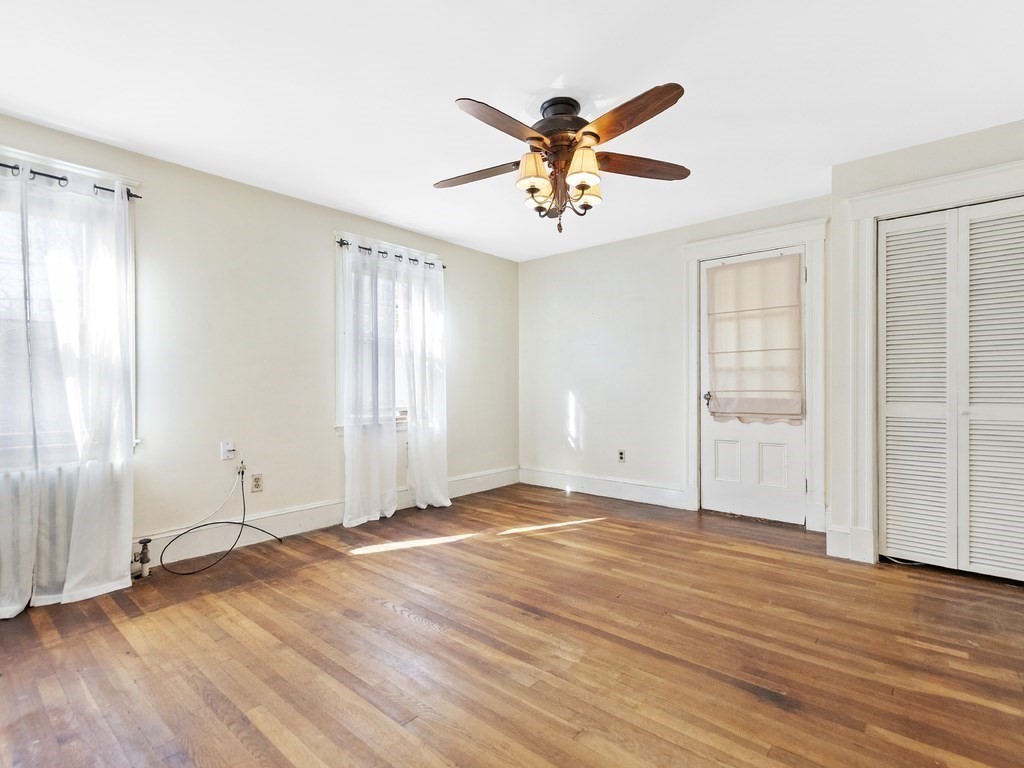 149 Trapelo Road Waltham, MA 02452 - Photo 22 of 36 an empty room with wooden floor closet and windows