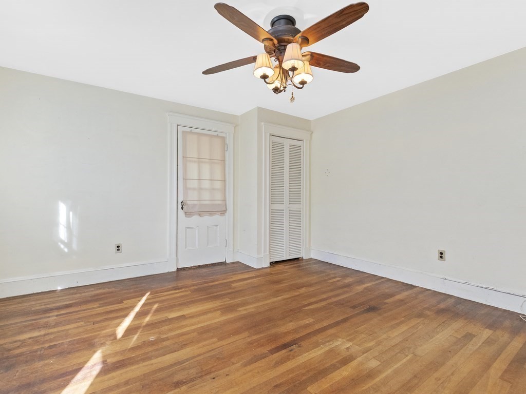 149 Trapelo Road Waltham, MA 02452 - Photo 23 of 36 an empty room with a chandelier fan and windows