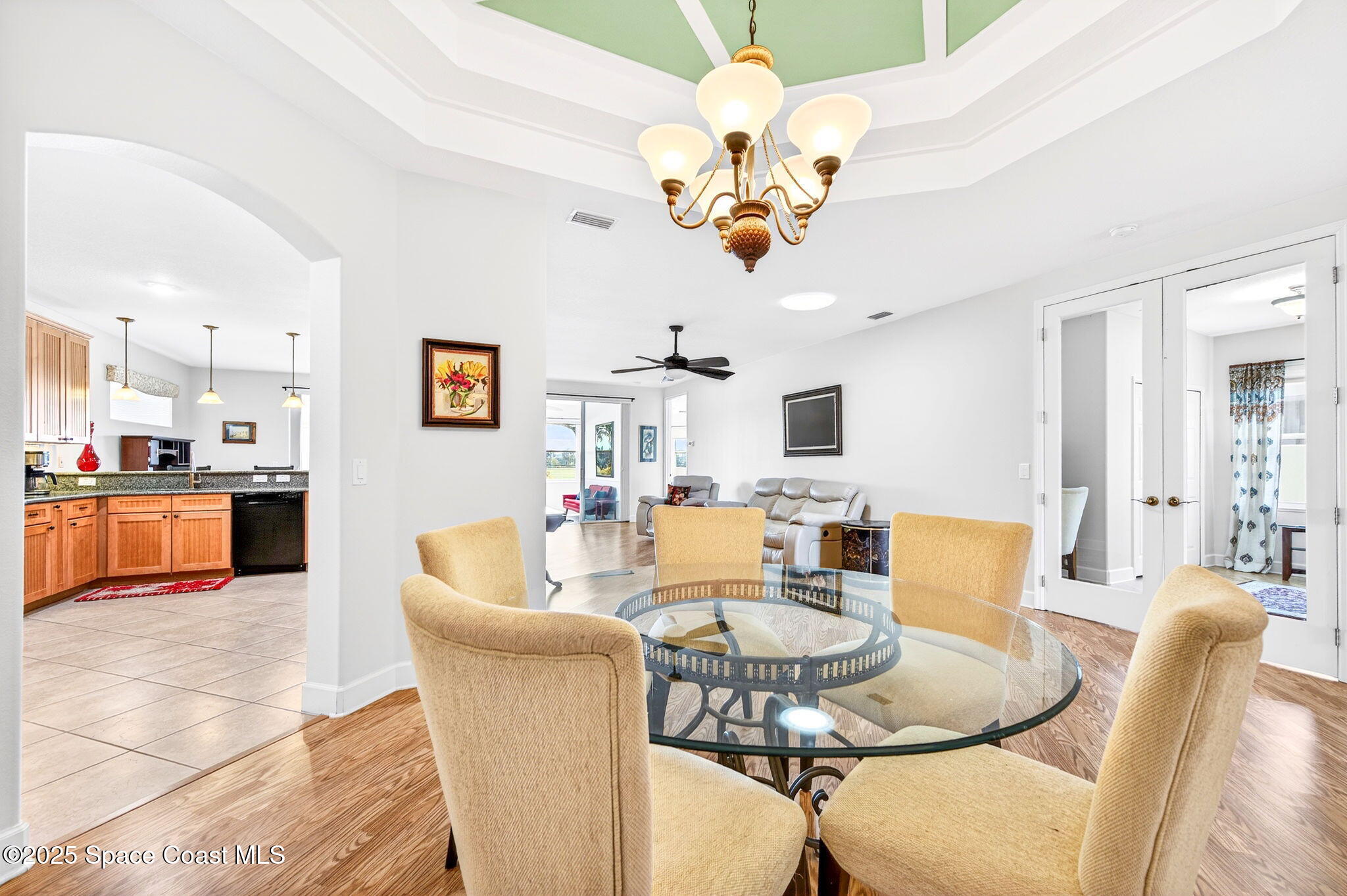 3407 Bancroft Drive Melbourne, FL 32940 - Photo 11 of 74 a dining room with wooden floor a chandelier a glass table and chairs