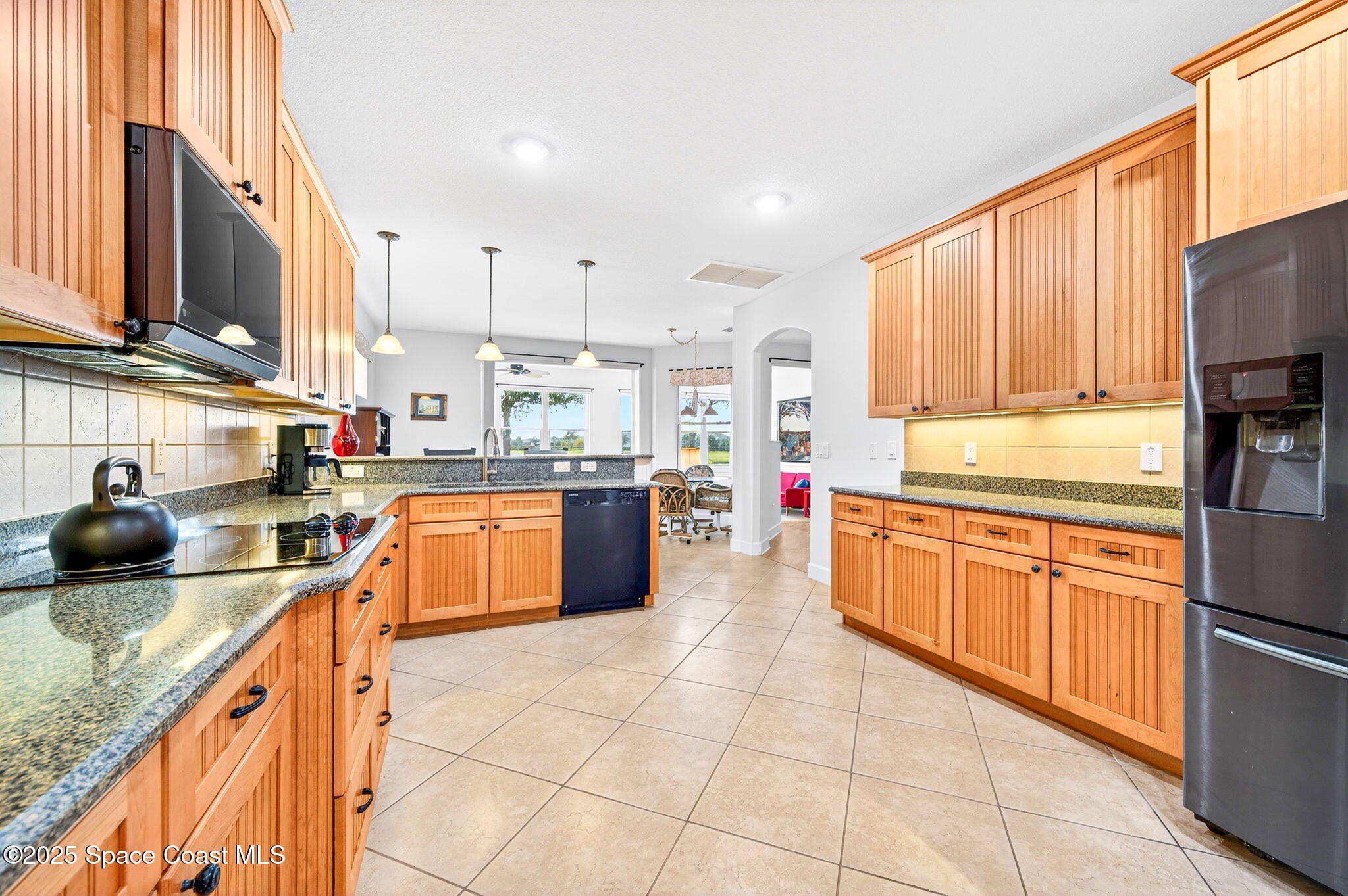 3407 Bancroft Drive Melbourne, FL 32940 - Photo 13 of 74 a kitchen with stainless steel appliances granite countertop a sink counter space cabinets and a large window