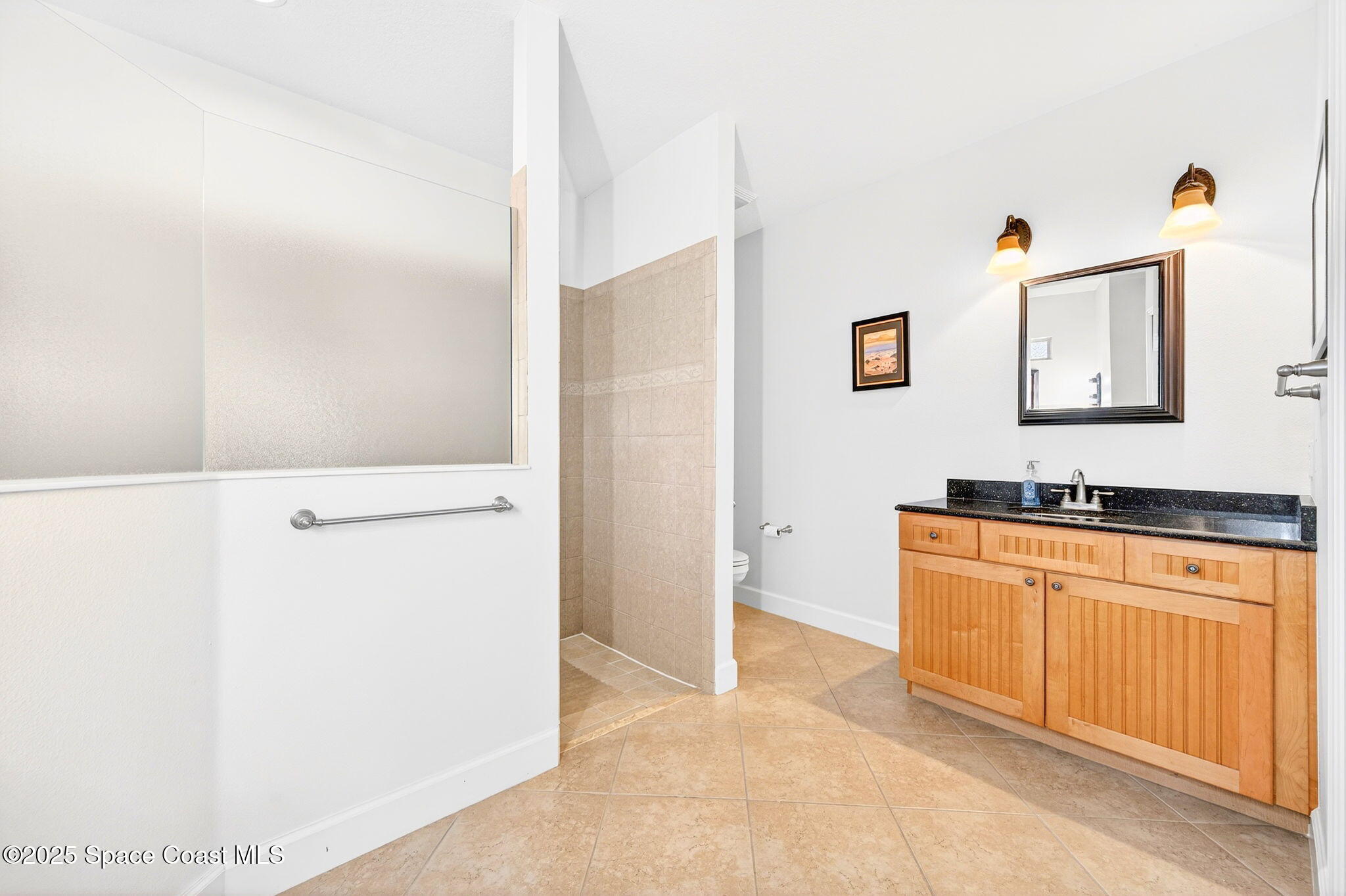 3407 Bancroft Drive Melbourne, FL 32940 - Photo 26 of 74 a bathroom with a sink a mirror and a shower