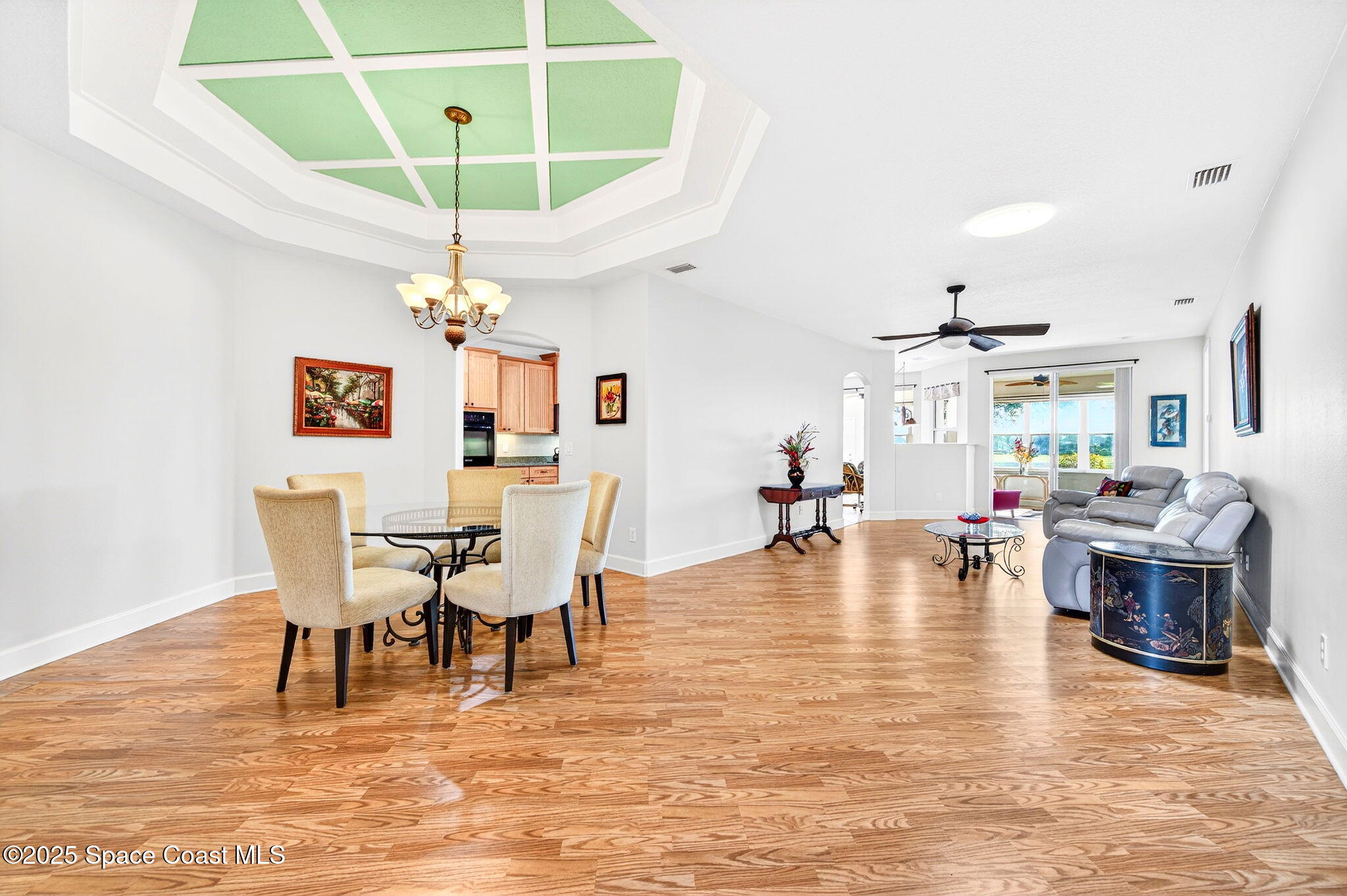3407 Bancroft Drive Melbourne, FL 32940 - Photo 6 of 74 a dining room with wooden floor a chandelier a wooden table and chairs