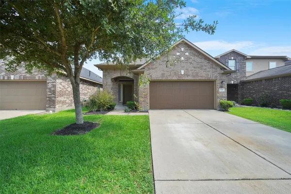 a front view of a house with a garden and yard