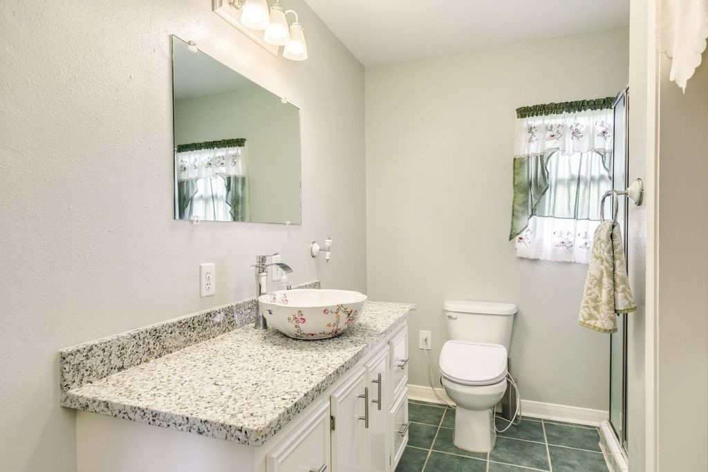 404 Chestnut Street Brazoria, TX 77422 - Photo 17 of 23 a bathroom with a granite countertop sink a toilet and a mirror