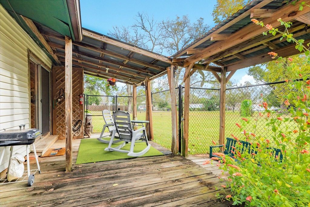 404 Chestnut Street Brazoria, TX 77422 - Photo 18 of 23 a view of porch with a table and chairs and floor to ceiling window next to a yard