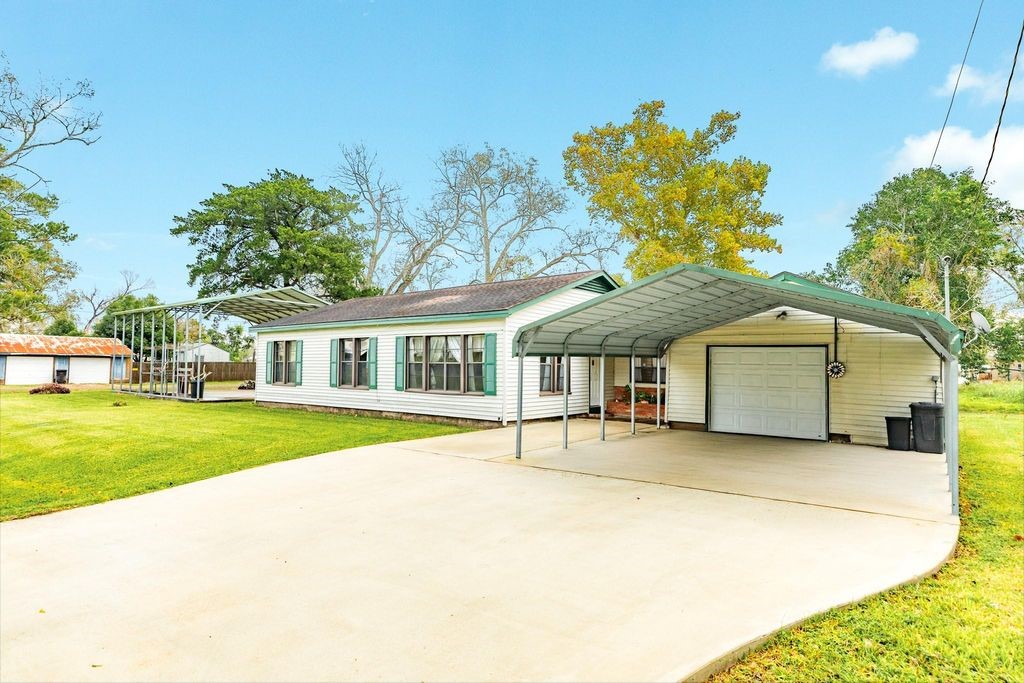 404 Chestnut Street Brazoria, TX 77422 - Photo 3 of 23 a front view of a house with a garden and trees