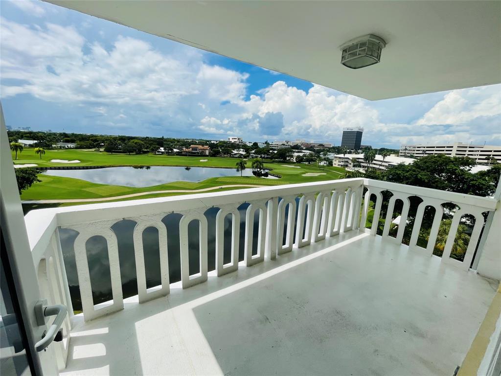 2500 Northeast 48th Lane, Unit 605 Fort Lauderdale, FL 33308 - Photo 1 of 32 a view of a balcony with wooden floor & fence
