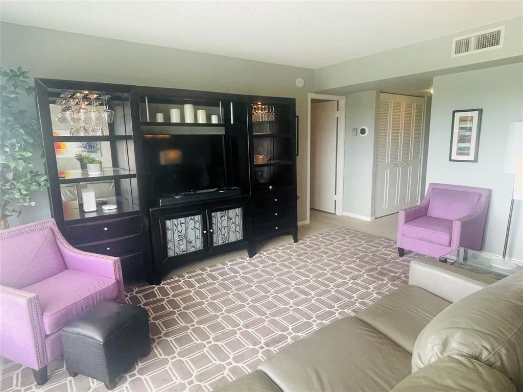 2500 Northeast 48th Lane, Unit 605 Fort Lauderdale, FL 33308 - Photo 11 of 32 a living room with furniture a flat screen tv and a fireplace