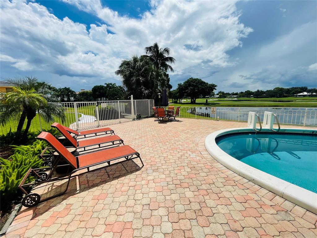 2500 Northeast 48th Lane, Unit 605 Fort Lauderdale, FL 33308 - Photo 28 of 32 a view of a swimming pool with a lounge chairs
