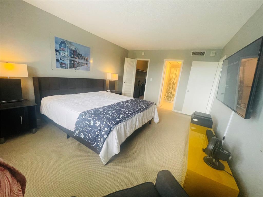 2500 Northeast 48th Lane, Unit 605 Fort Lauderdale, FL 33308 - Photo 3 of 32 a bedroom with a bed and flat screen tv