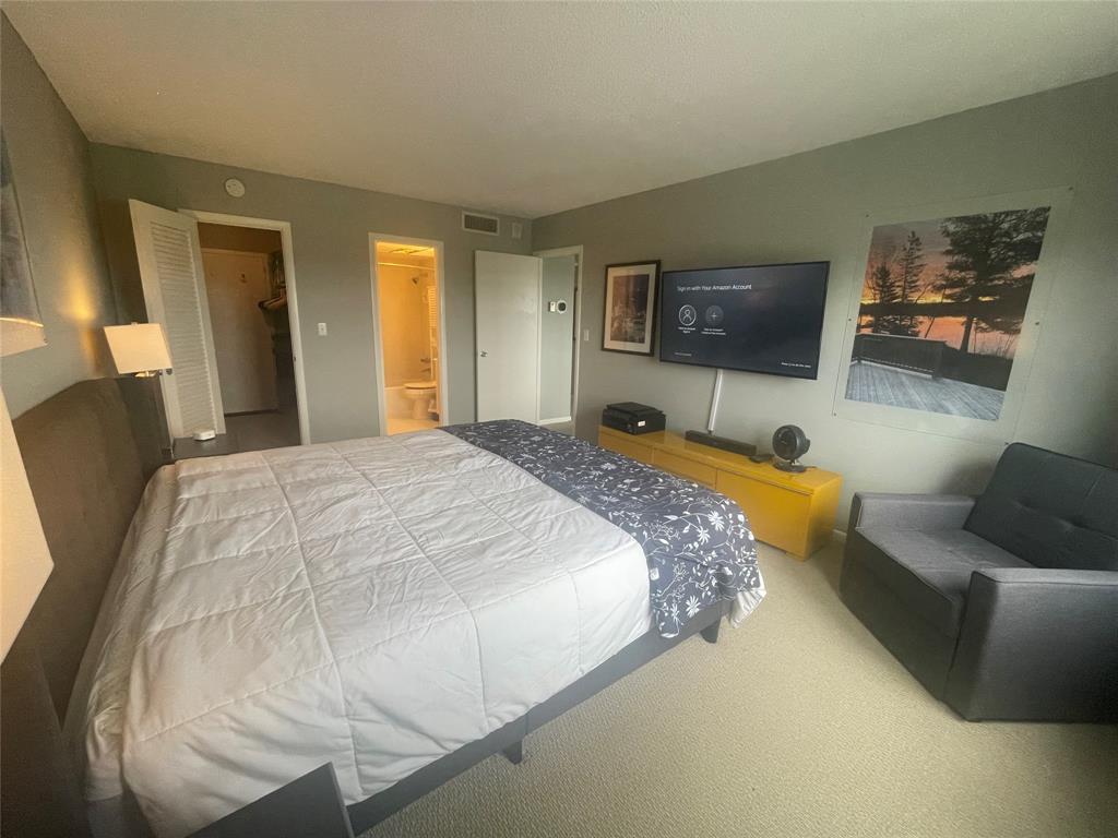 2500 Northeast 48th Lane, Unit 605 Fort Lauderdale, FL 33308 - Photo 6 of 32 a spacious bedroom with a bed and a flat screen tv