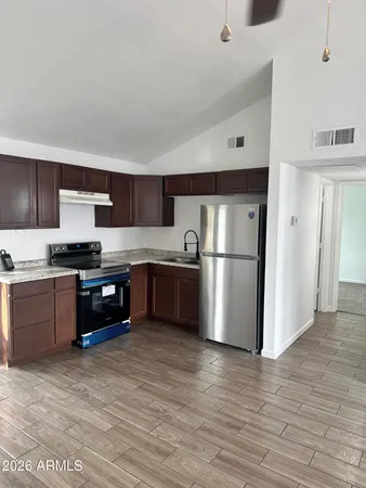 a kitchen with granite countertop a refrigerator and a stove top oven
