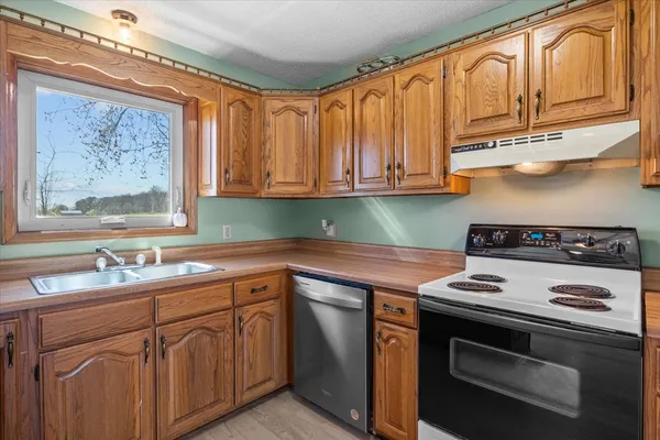 a kitchen with stainless steel appliances granite countertop a sink a stove and a microwave