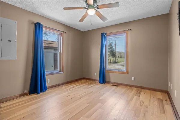 a view of an empty room with window and wooden floor