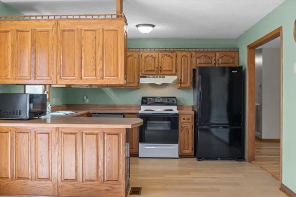 a kitchen with a refrigerator and a stove top oven