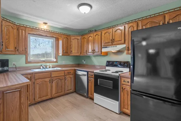 a kitchen with stainless steel appliances granite countertop a stove a sink and a refrigerator