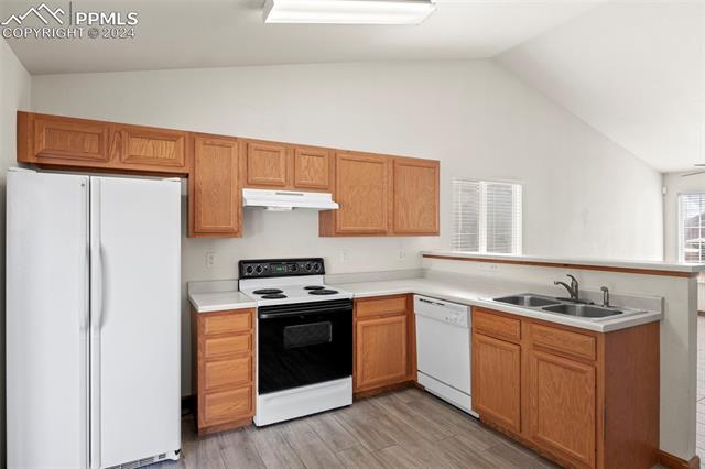 4763 Brant Road Colorado Springs, CO 80911 - Photo 12 of 26 Kitchen with ceiling fan, sink, light hardwood / wood-style flooring, kitchen peninsula, and white appliances