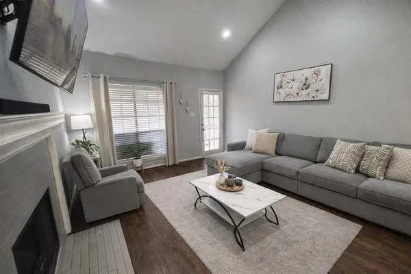 a living room with furniture a rug and a large window