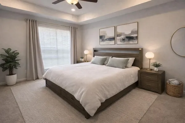 a bedroom with a large bed and a chandelier fan