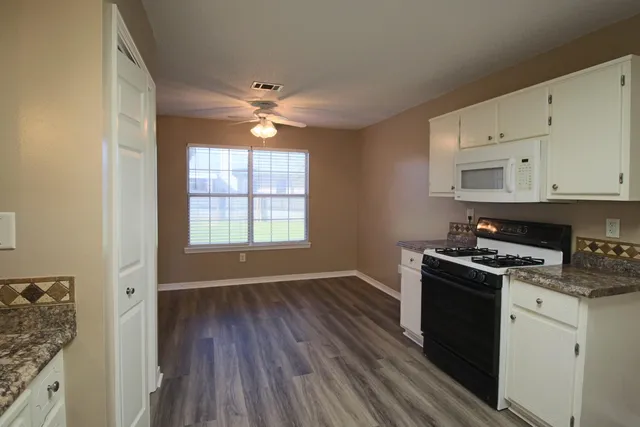 a kitchen with a refrigerator and a stove top oven