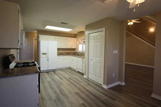 a kitchen with a refrigerator stove and white cabinets