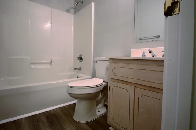 an empty room with wooden floor chandelier fan and window