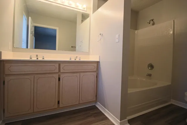 a bathroom with a granite countertop toilet a sink and a bathtub