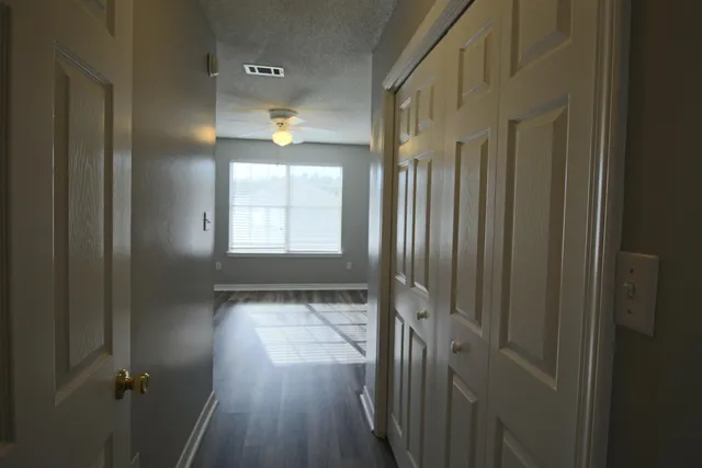 an empty room with wooden floor and windows