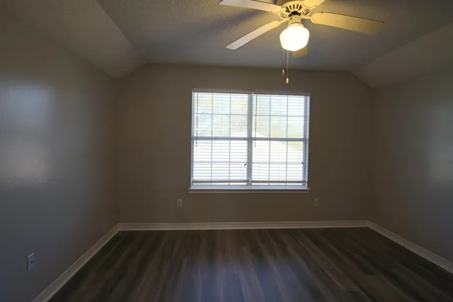 an empty room with wooden floor and door