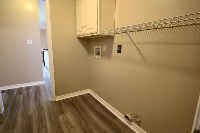 an empty room with wooden floor and cabinet