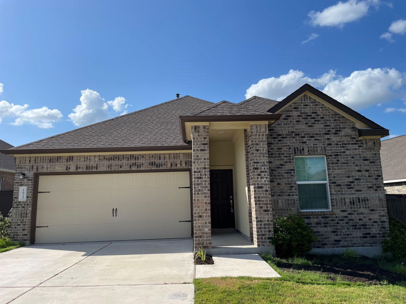 1625 Woolsey Way Leander, TX 78641 - Photo 1 of 17 The property features a brick exterior, a two-car garage, and a covered entryway