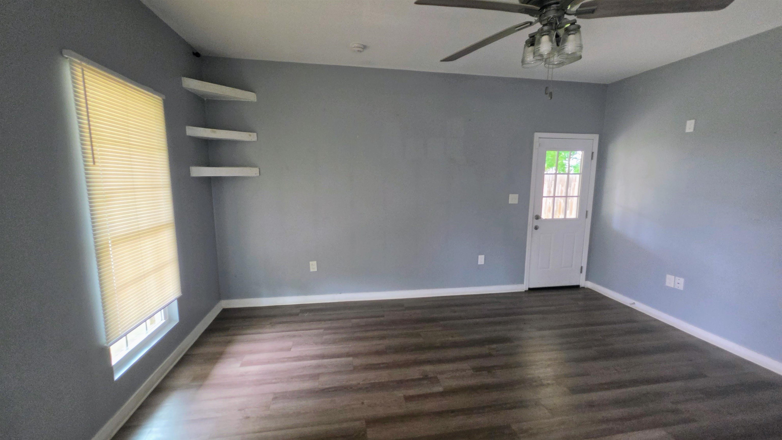 1551 Cane Road Memphis, TN 38106 - Photo 4 of 5 Spacious room featuring wood-finish flooring, a ceiling fan with integrated lighting, and a window with blinds