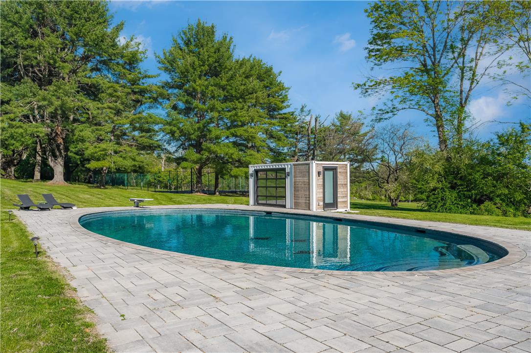 1506 Pleasant View Road Coopersburg, PA 18036 - Photo 86 of 97 An inviting in-ground pool with a modern pool house sits amidst lush greenery, perfect for leisure.