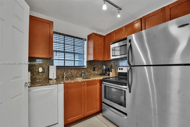 a kitchen with stainless steel appliances a refrigerator sink and cabinets