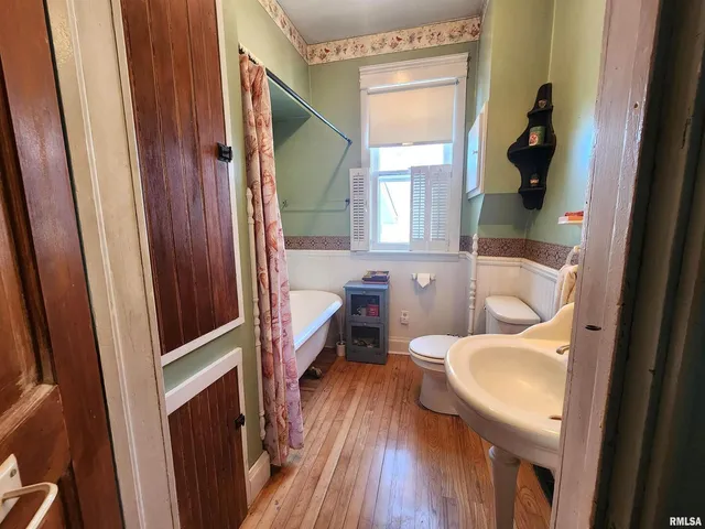 a hallway with wooden floor furniture and a window