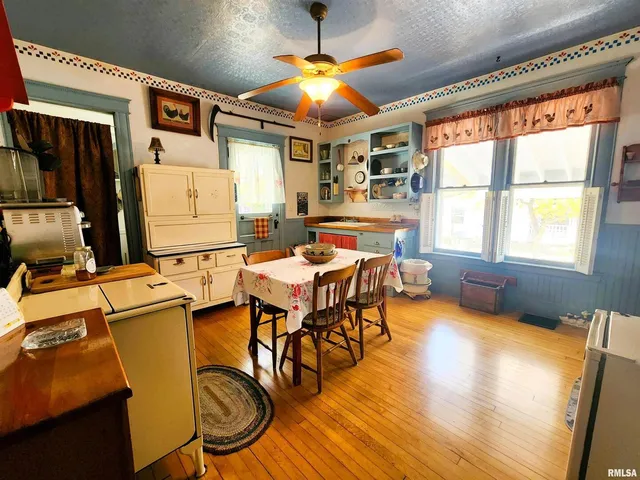 a dining room with furniture a chandelier and wooden floor