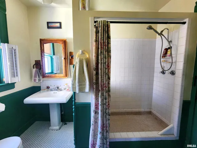 a bathroom with a sink a mirror and a shower