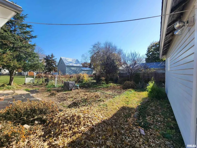 a view of a yard with wooden fence