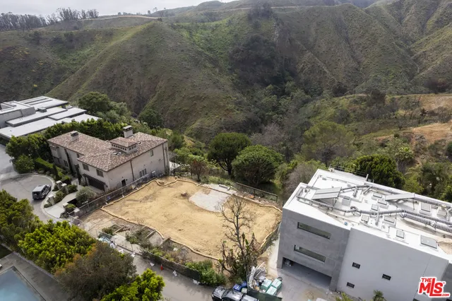 a view of a backyard with plants and outdoor seating