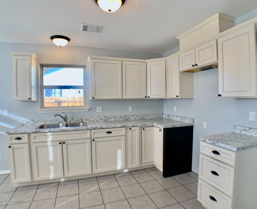 4213 South Harrison Street Amarillo, TX 79110 - Photo 4 of 14 a kitchen with white cabinets appliances and a sink