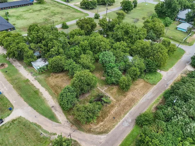 an aerial view of residential house with outdoor space and trees all around