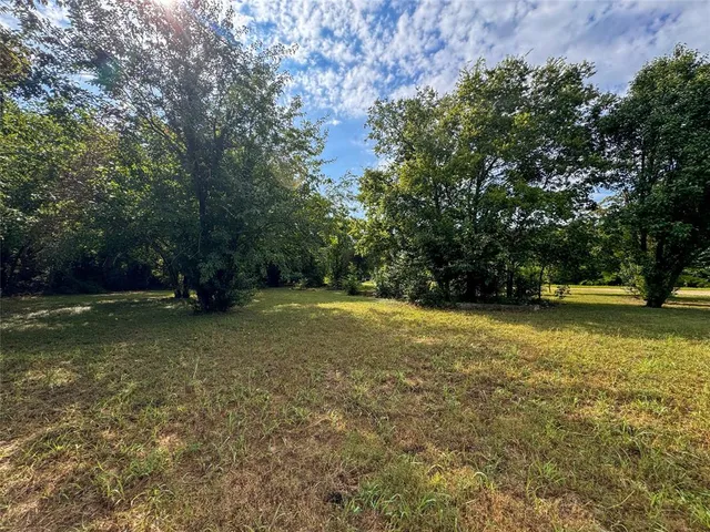 an aerial view of residential houses with outdoor space and trees all around