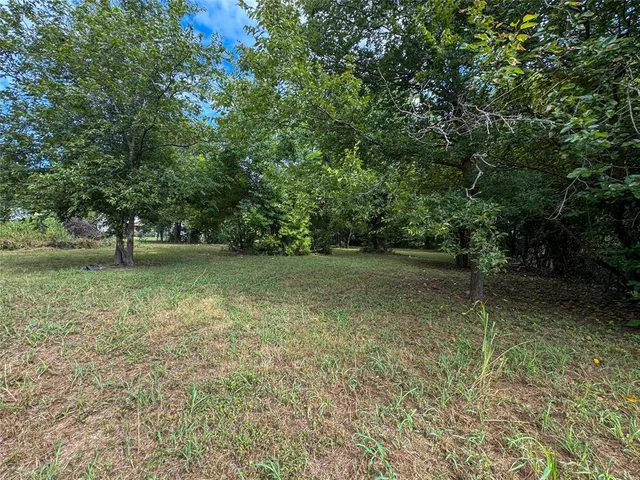 an aerial view of residential houses with outdoor space and trees