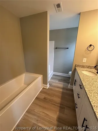 a spacious bathroom with a granite countertop sink and a mirror