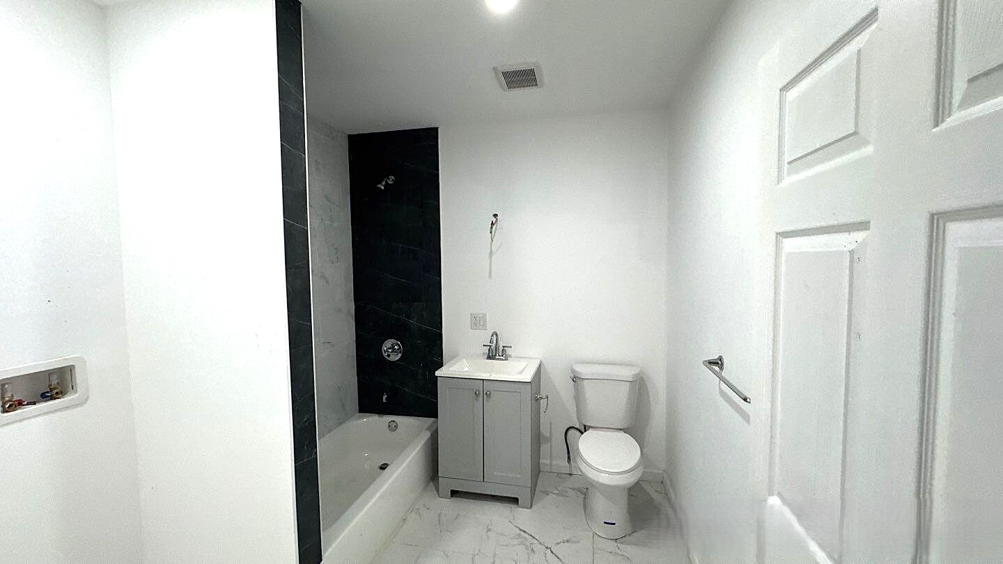 830 Hendrix Street Brooklyn, NY 11207 - Photo 21 of 25 a bathroom with a granite countertop toilet and a sink